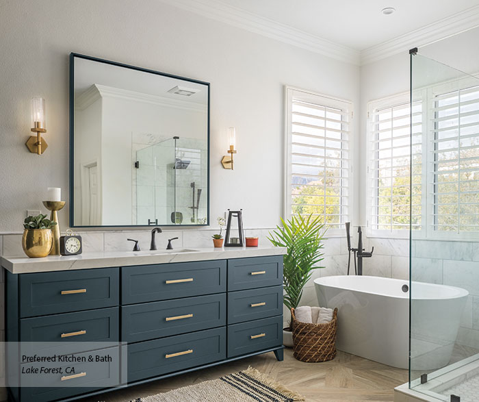 bathroom with white tub and sink cabinetry in blue
